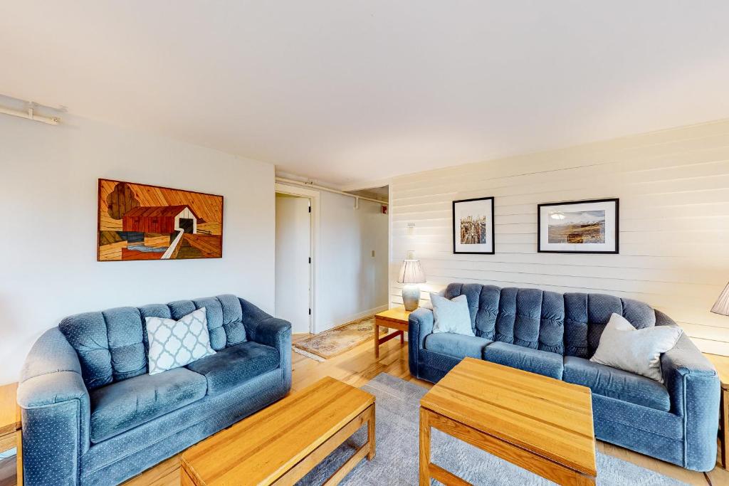 a living room with two blue couches and a table at Mountainside Resort B202 in Stowe