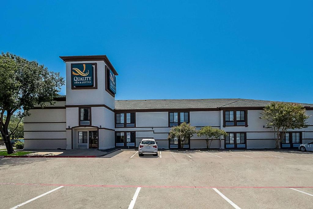 a building with a car parked in a parking lot at Quality Inn & Suites Irving DFW Airport South in Irving
