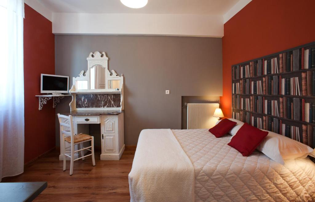 a bedroom with a large bed and a book shelf at Hôtel la Bona Casa in Collioure