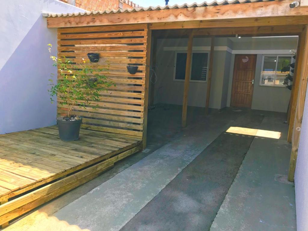 een houten garage met een potplant erop bij casa palhoça in Palhoça