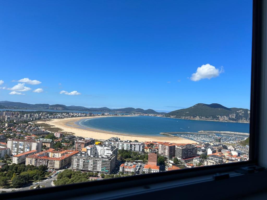 Blick auf den Strand und das Meer aus dem Fenster in der Unterkunft Encantador apartamento recién reformado a estrenar in Laredo