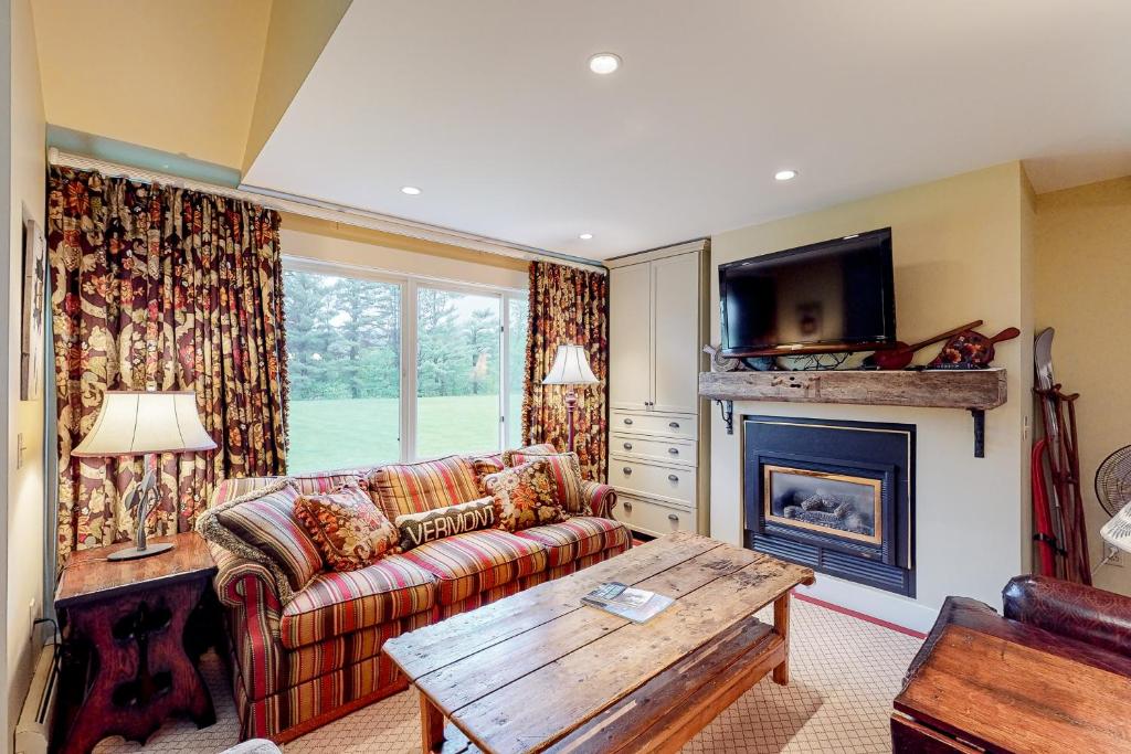 a living room with a couch and a fireplace at Village Green Unit 14E in Stowe