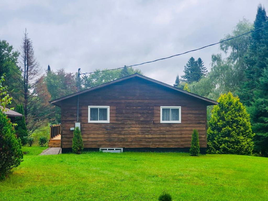 una casa de madera con un césped verde delante de ella en Minden Cottage Getaway, en Minden