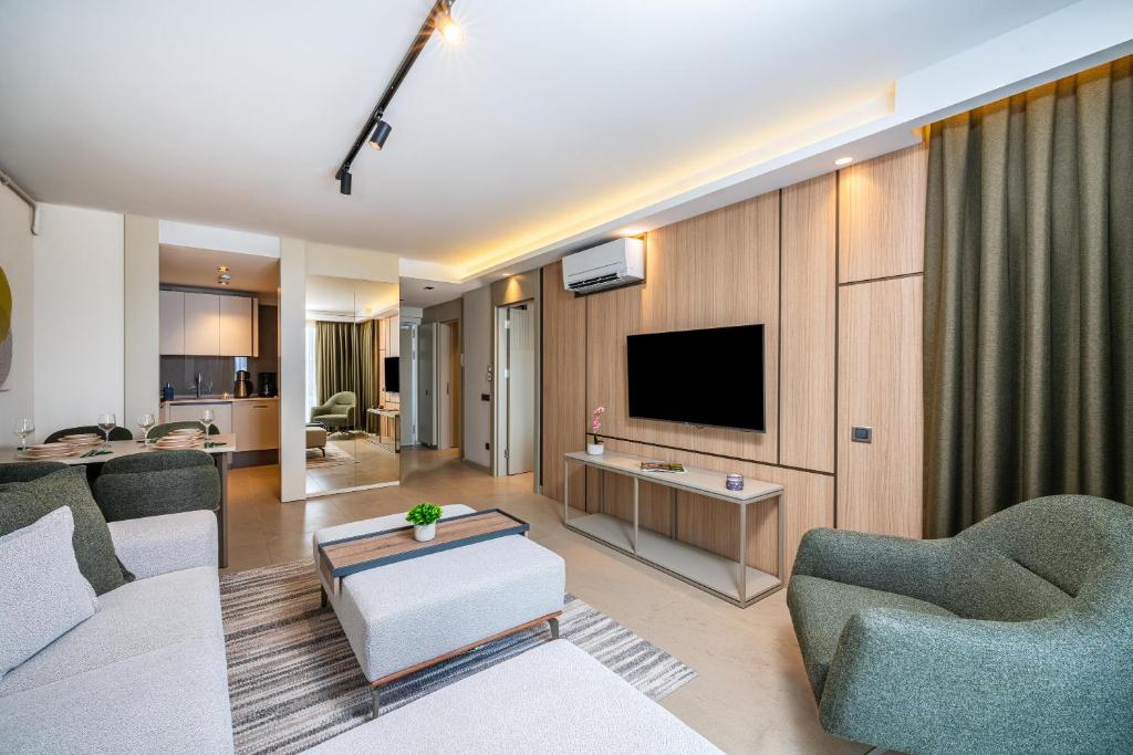 a living room with a couch and a tv at Casamax Suites in Antalya