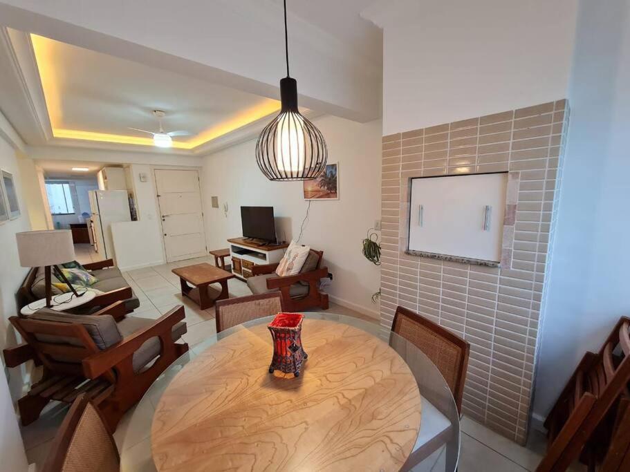 een kamer met een tafel en stoelen en een woonkamer bij Apartamento pé na areia e piscina in Capão da Canoa