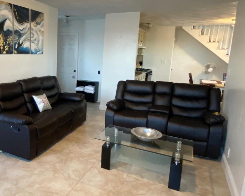 a living room with two leather couches and a table at Spacious 2nd floor split level with scenic views of Gloucester in Gloucester