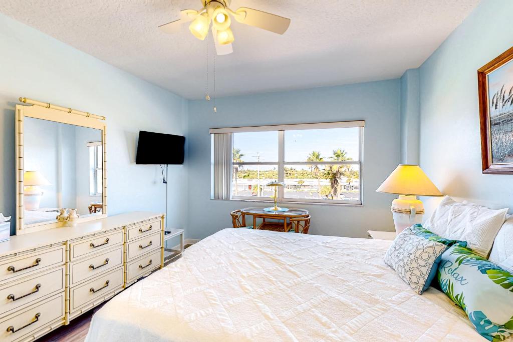 a bedroom with a bed and a dresser and a window at Turtle Time Suite in Satellite Beach