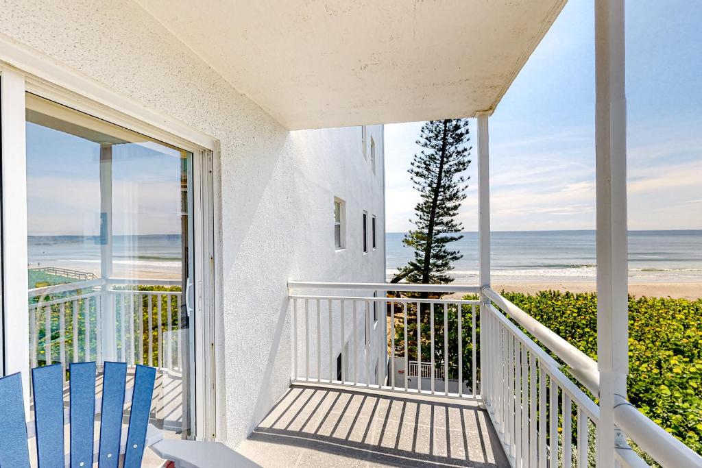 a balcony with two chairs and a view of the beach at Turtle Time Suite in Satellite Beach