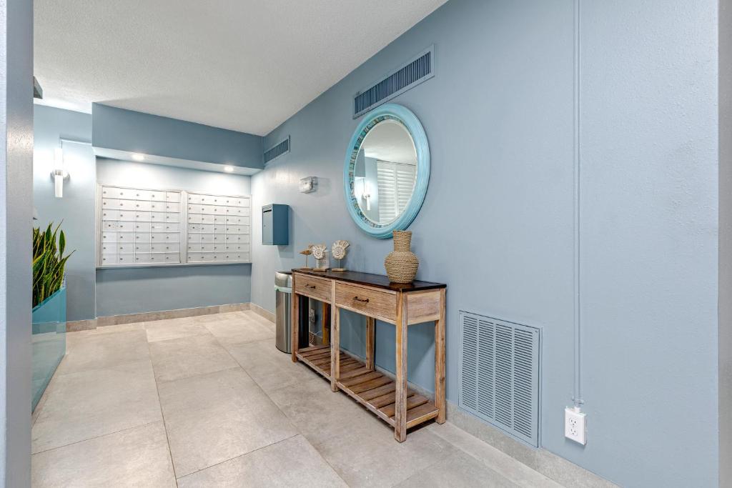 a blue bathroom with a table and a mirror at Turtle Time Suite in Satellite Beach