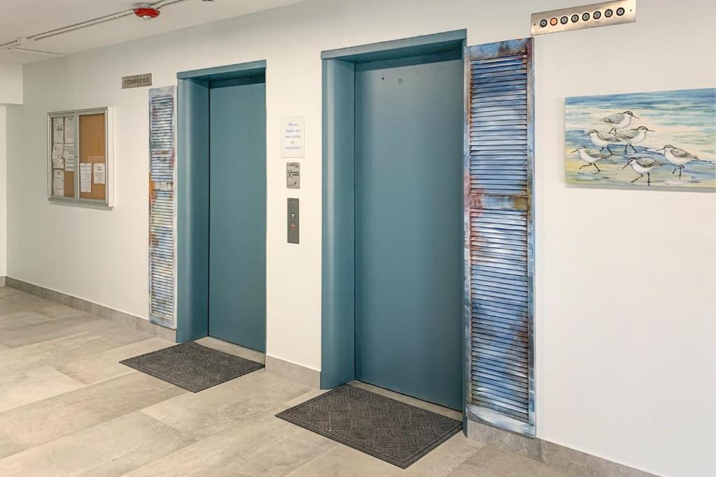 a row of blue elevator doors in a room at Turtle Time Suite in Satellite Beach