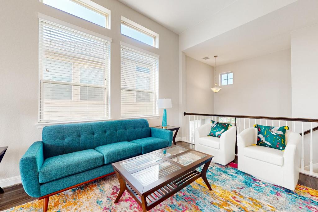 - un salon avec un canapé bleu et deux fauteuils blancs dans l'établissement Balanced at Brachetto, à San Antonio