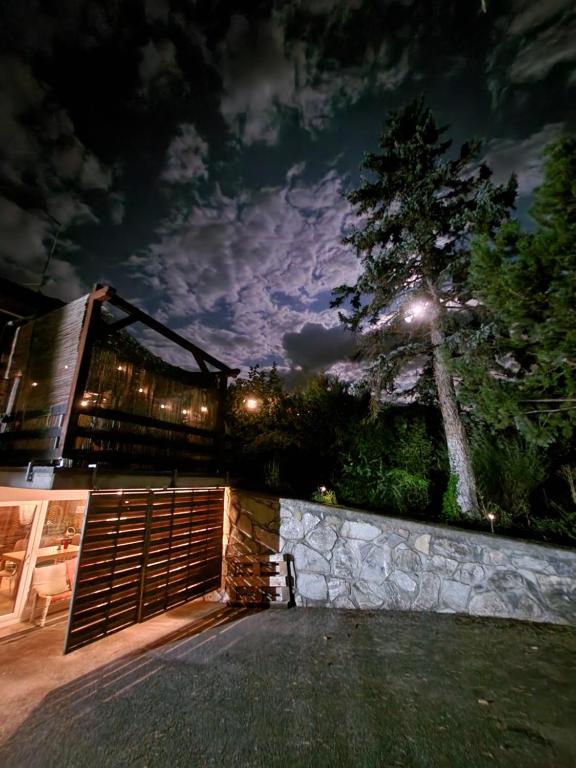 a house with a fence and a tree at night at Chez Pipo in Conthey