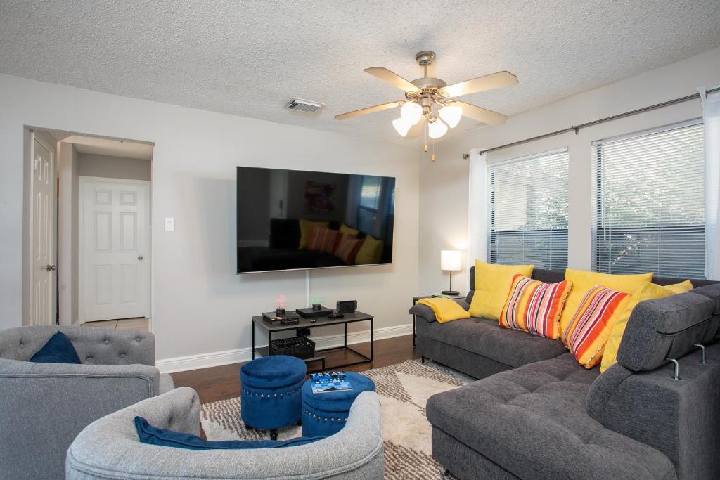 a living room with two couches and a ceiling fan at Super Fun House in Perfect Location in San Antonio