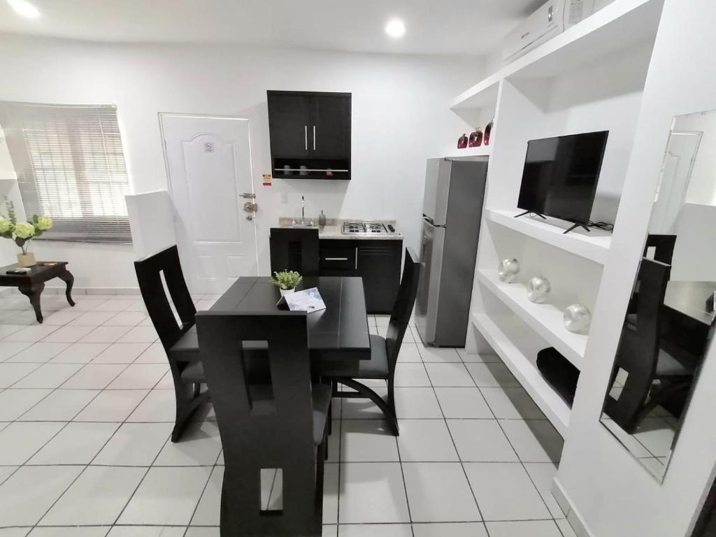 uma cozinha com uma mesa preta e cadeiras em COMODO DEPARTAMENTO VACACIONAL A 5 MIN. DEL MALECON em Mazatlán