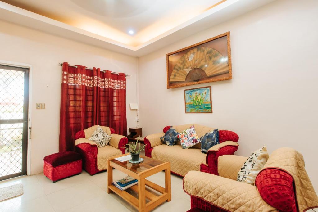 ein Wohnzimmer mit 2 Sofas und einem Tisch in der Unterkunft Bahay Ni Kikay Vacation Rental - WiFi Included in General Santos