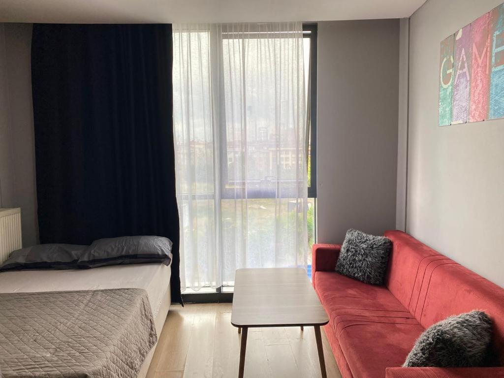 a bedroom with a red couch and a window at Ikon Suit in Istanbul