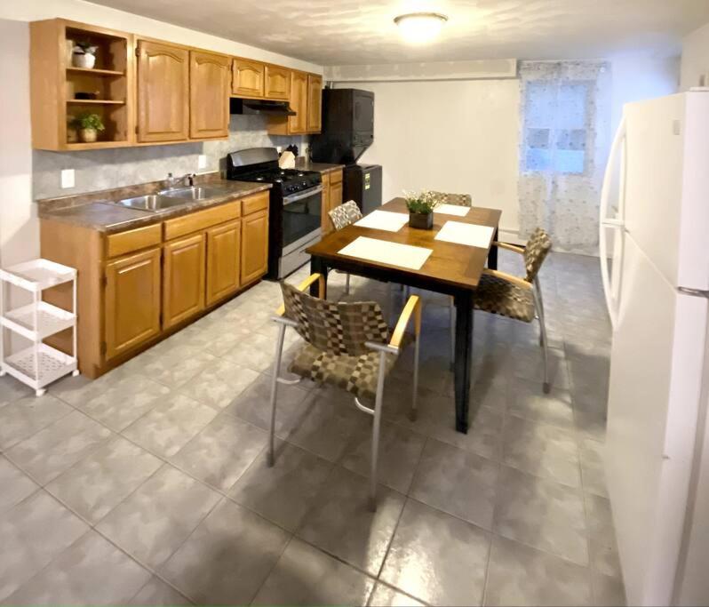 uma cozinha com uma mesa e cadeiras e um frigorífico em Glorious Suite near Downtown with washer/dryer em Gloucester