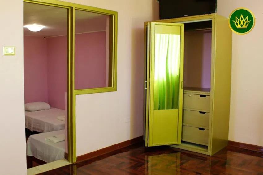 Habitación con puertas verdes y dormitorio con cama. en HOTEL REY DE ORO, en Chiclayo