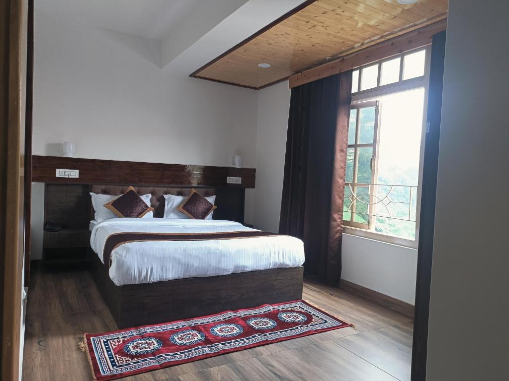 um quarto com uma cama grande e uma janela em HOTEL ANGS RETREAT em Gangtok