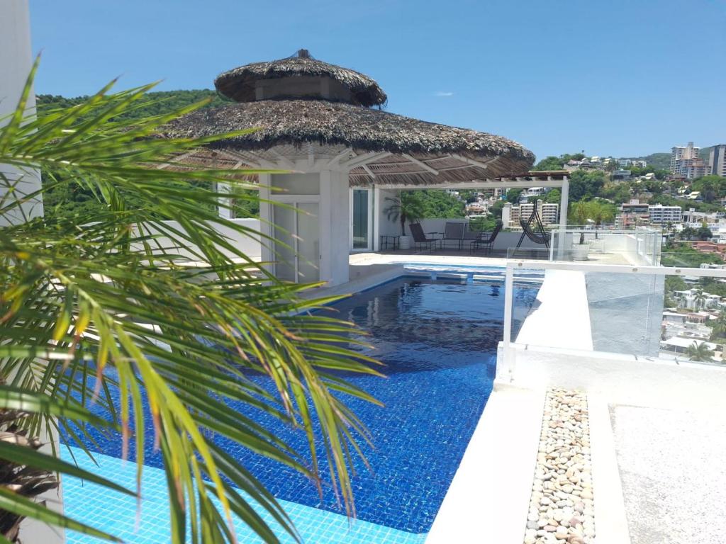a villa with a swimming pool and an umbrella at CLUB DE GOLF in Acapulco