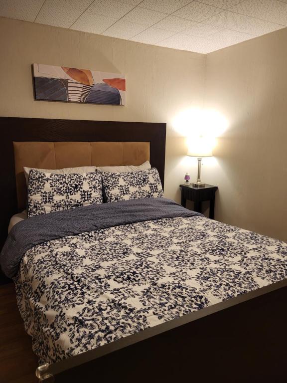 a bedroom with a bed with a black and white comforter at Cozy Private Rooms in Suite in Edmonton