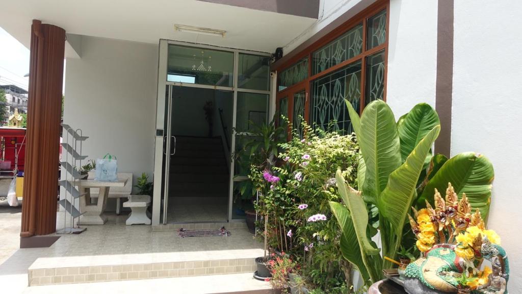 una porta d'ingresso di una casa con piante e fiori di ธิติกาญจน์ อพาร์ทเม้นท์ a Ban Khlong Samrong