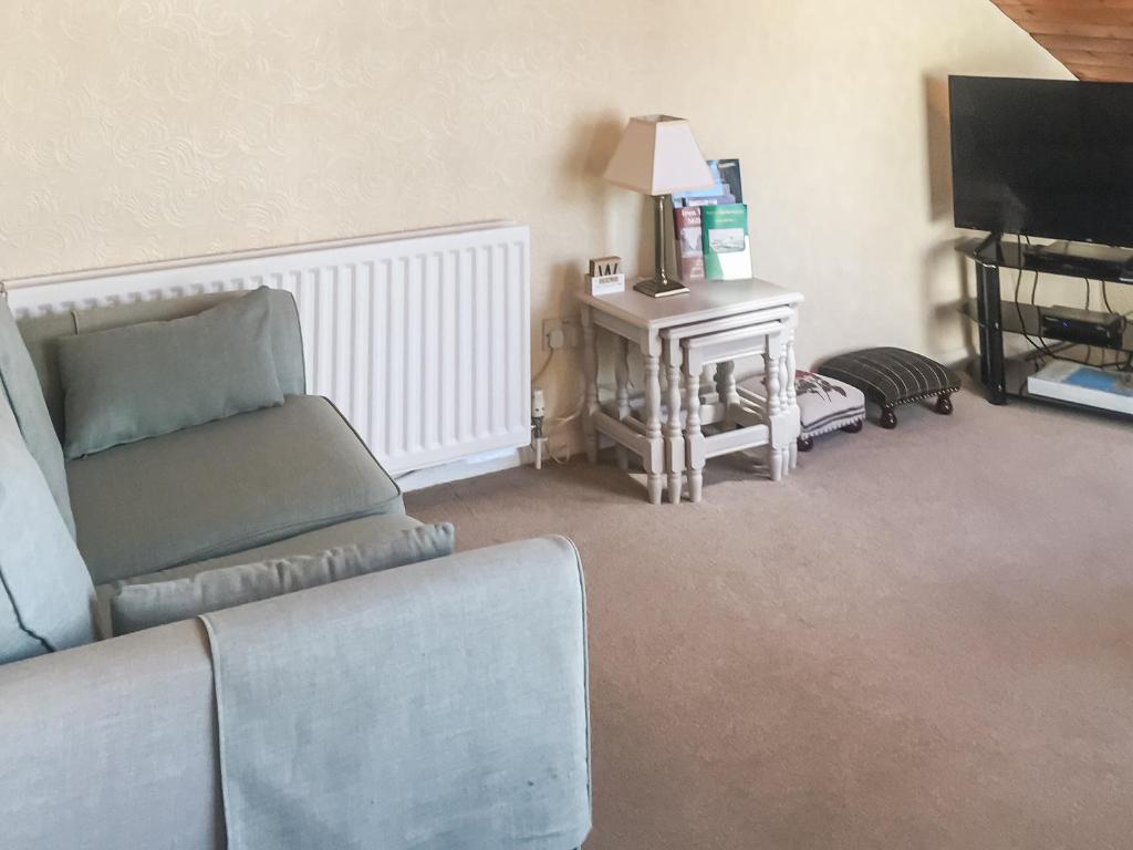 a living room with a couch and a television at Harbour Cottage in Millom