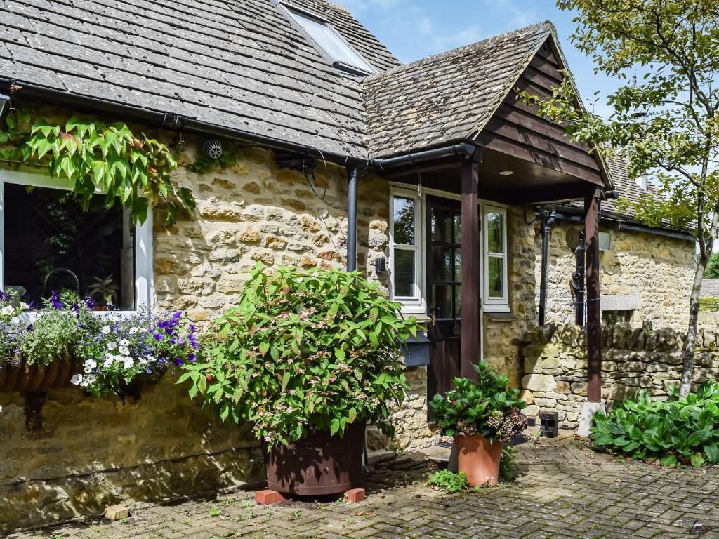 a stone cottage with flowers in front of it at The Barn in Ramsden