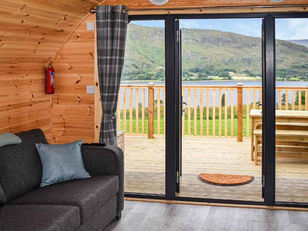 a living room with a couch and a sliding glass door at Black Grouse - Ukc6790 in Fort William