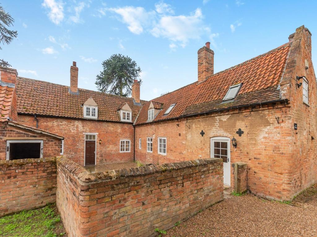 an old brick building with a brick wall at The Farmhouse - Uk45171 in Southwell