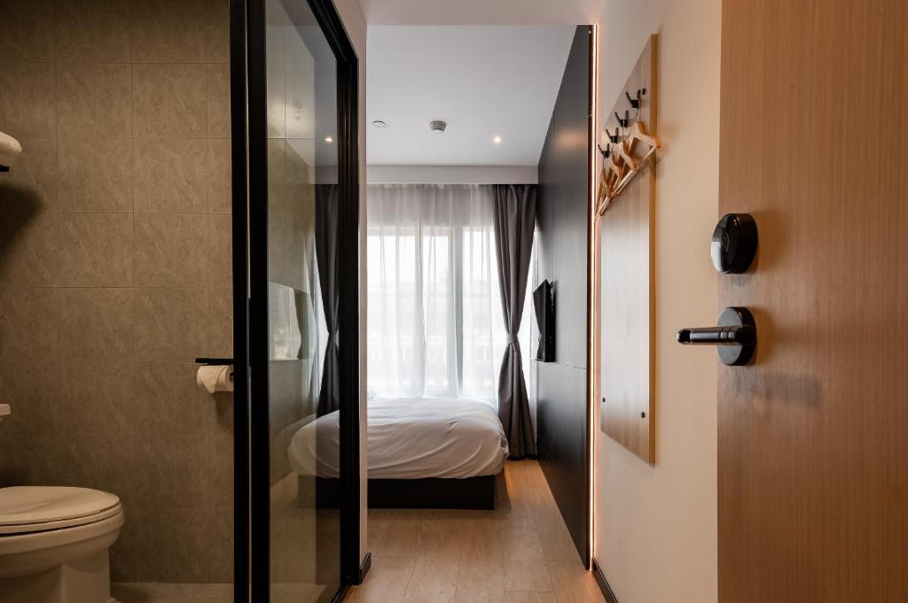 a bathroom with a toilet and a bed in a room at Dayin East Nanjing Road & The Bund in Shanghai