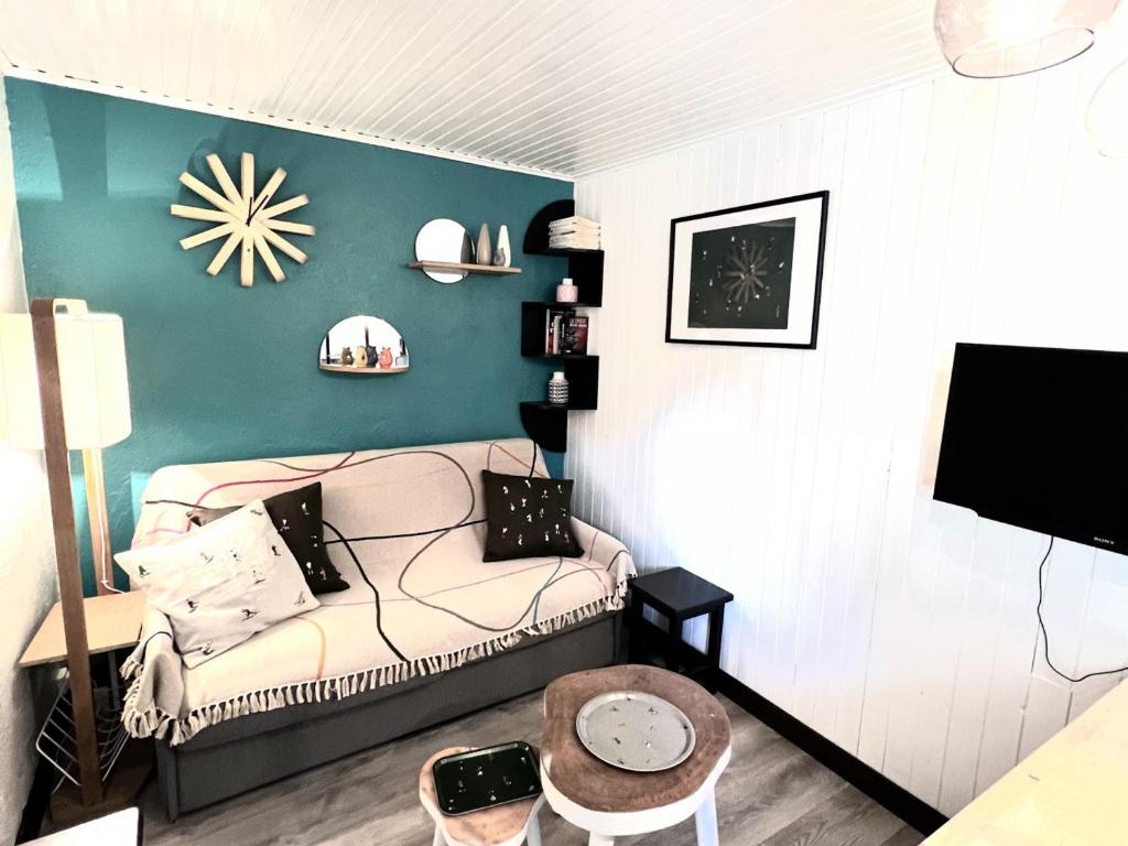 un salon avec un canapé et une horloge au mur dans l'établissement Appartement cosy au cœur des Gets, proche des télécabines, 2 chambres, Wi-Fi, parking privatif - FR-1-671-124, aux Gets