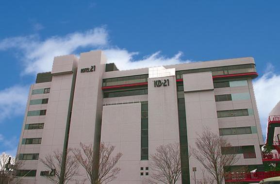un gran edificio blanco con un cartel. en Hotel 21 en Kusatsu
