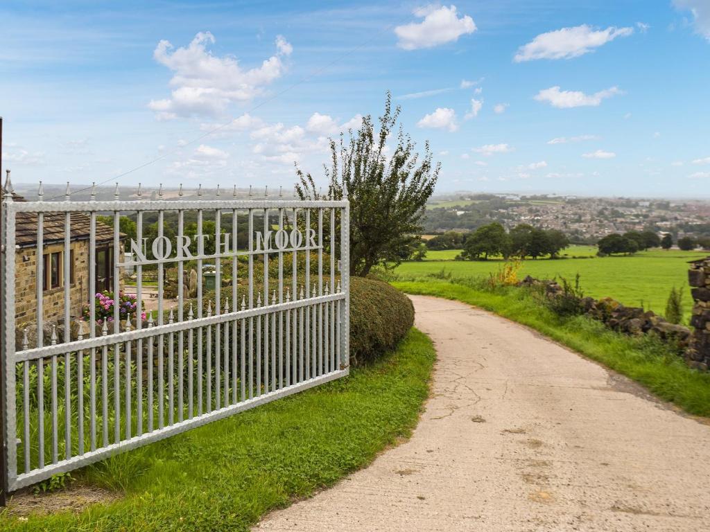 a fence on the side of a dirt road at North Moor Farm Shepherds Hut in Bradley