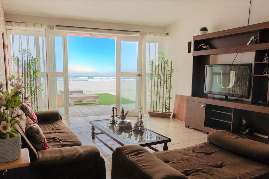 sala de estar con sofá y TV en Magnífica Casa de playa 3BR, en Lurín