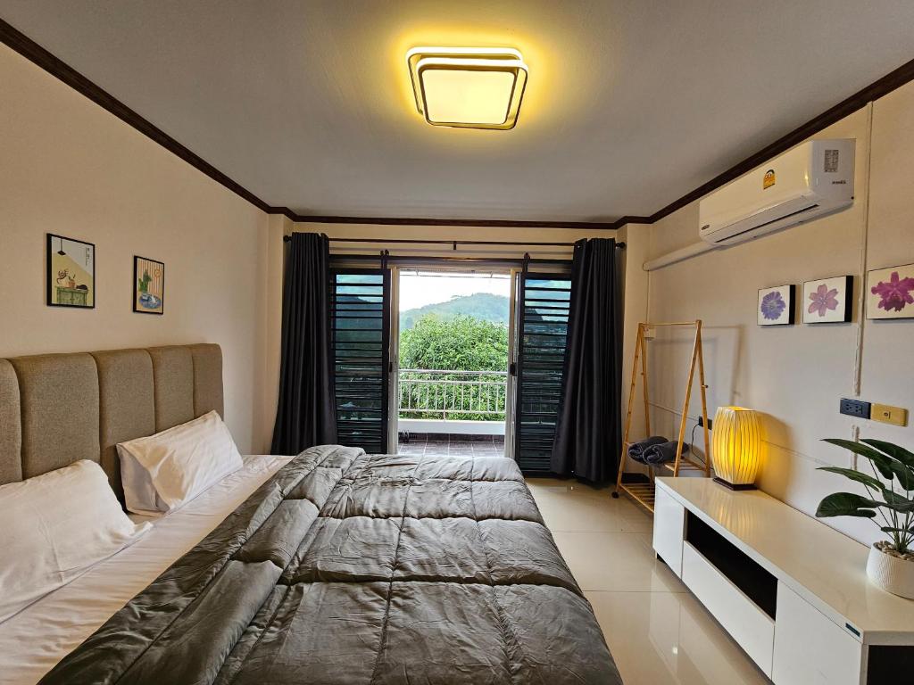 a bedroom with a large bed and a window at Anda Betong Homestay in Ban Komo Sip Paet