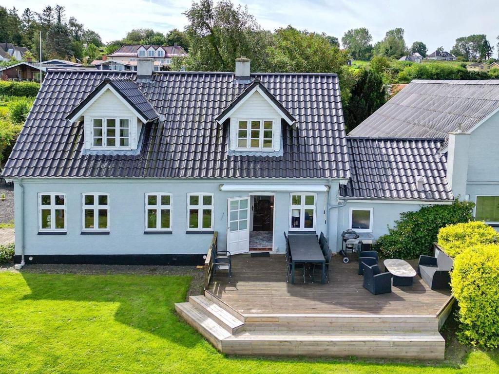 a house with a wooden deck in the yard at 4 star holiday home in Asperup-By Traum in Asperup