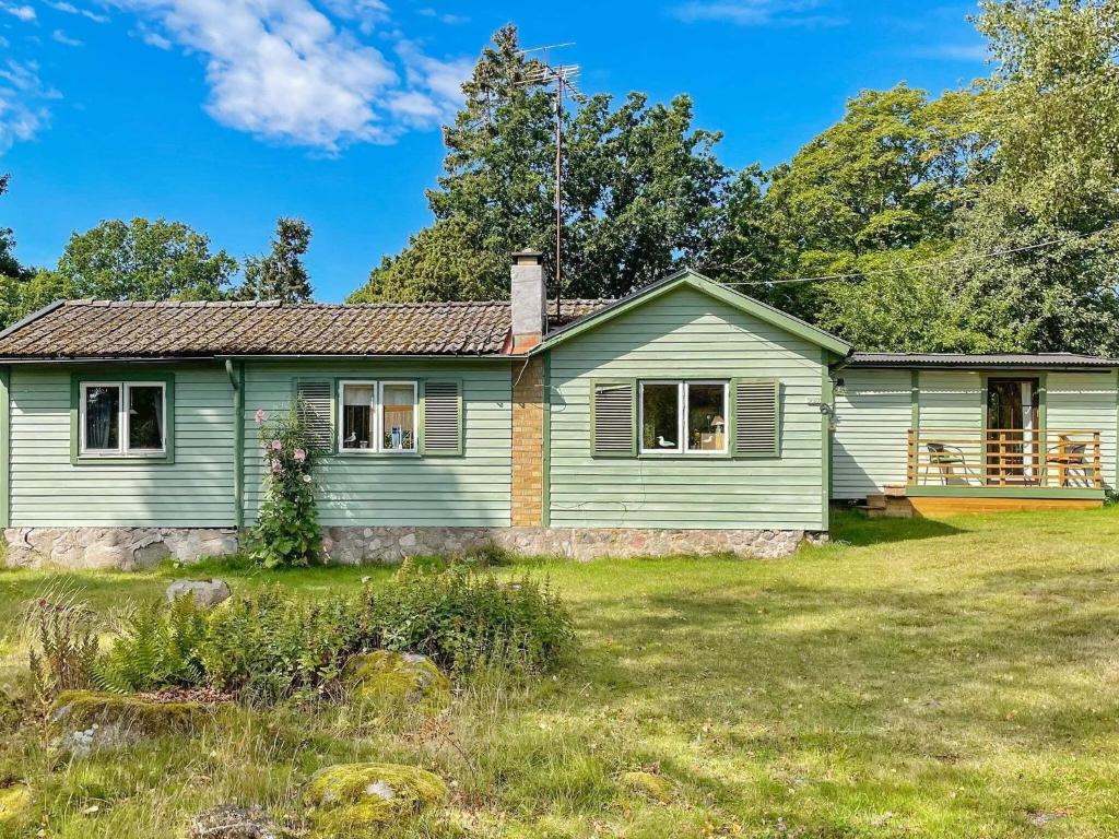 a small green house with a yard at Holiday home BERGKVARA X in Bergkvara