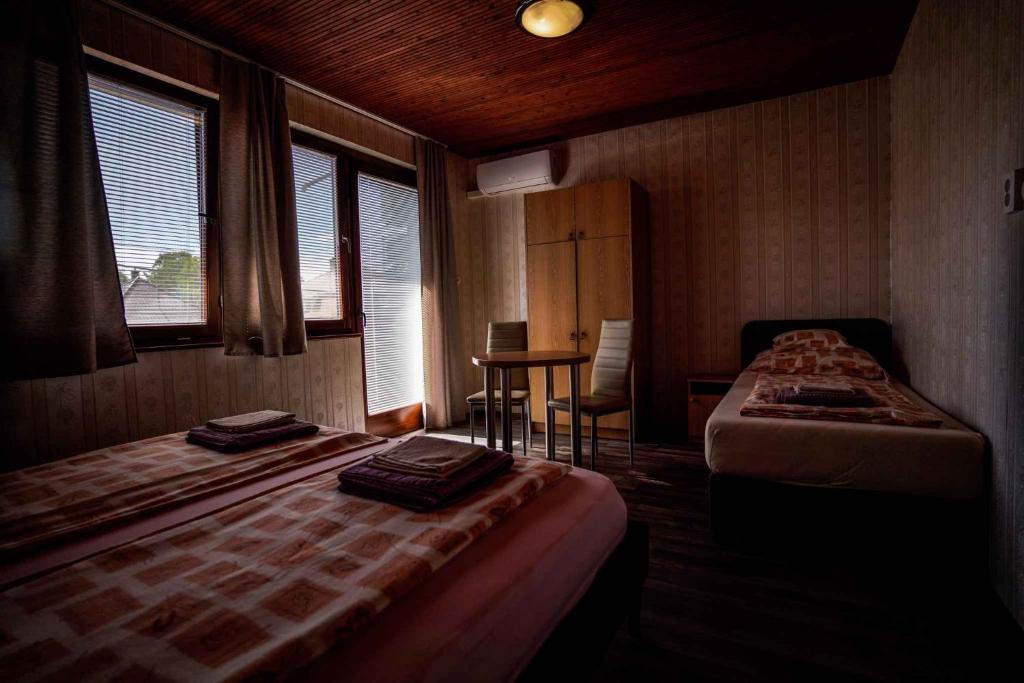 Cette chambre comprend deux lits et une table avec un bureau. dans l'établissement Apartment in Balatonföldvar 45317, à Balatonföldvár