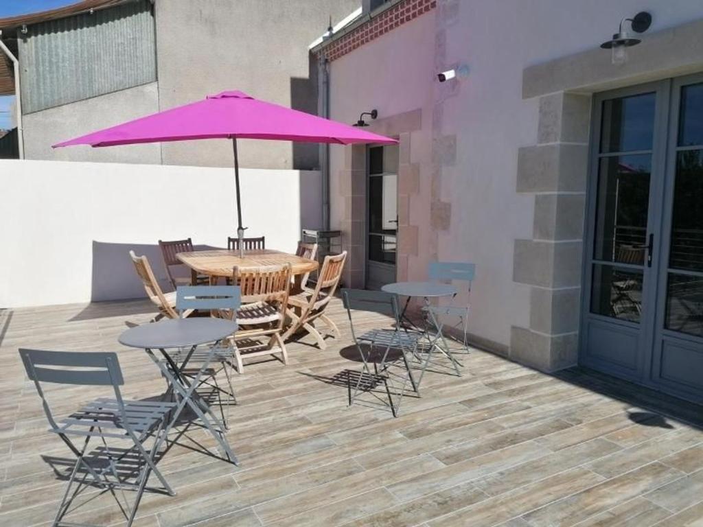 a table and chairs with a purple umbrella on a patio at Guestroom Briare, 1 pièce, 2 personnes - FR-1-590-369 in Briare