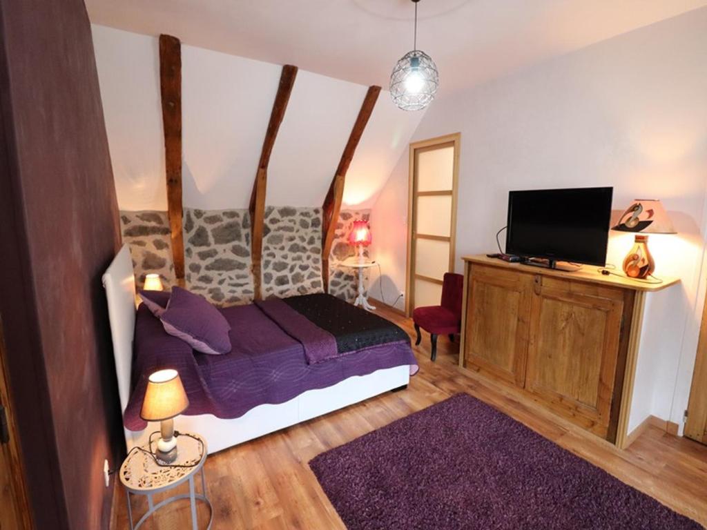 a bedroom with a bed and a flat screen tv at Gîte Fontanges, 4 pièces, 6 personnes - FR-1-742-413 in Fontanges