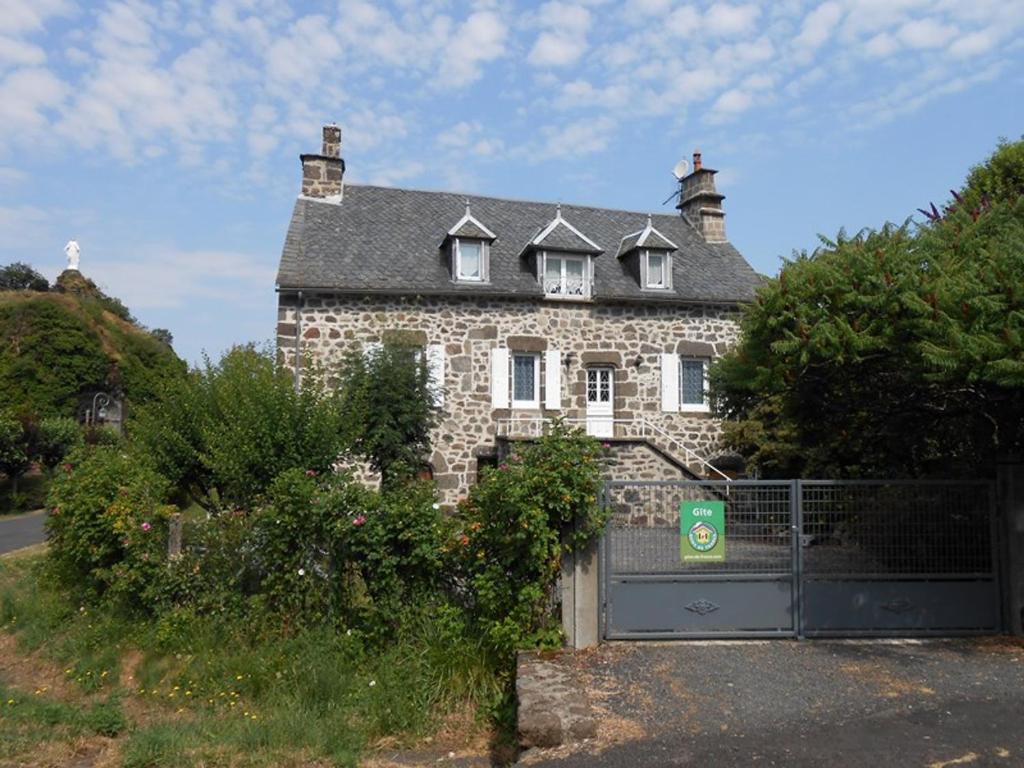 an old stone house with a fence in front of it at Gîte Fontanges, 4 pièces, 6 personnes - FR-1-742-413 in Fontanges