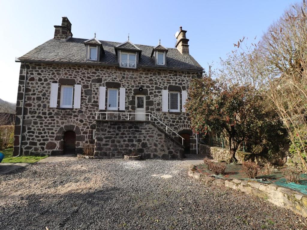 an old stone house with a driveway in front of it at Gîte Fontanges, 4 pièces, 6 personnes - FR-1-742-413 in Fontanges