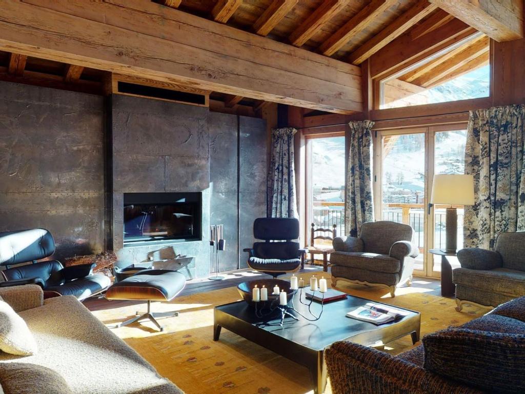 un salon rempli de meubles et d'une cheminée dans l'établissement Chalet avec Piscine Chauffée, Accès Direct aux Pistes et Services de Luxe à Val-d'Isère - FR-1-567-108, à Val dʼIsère