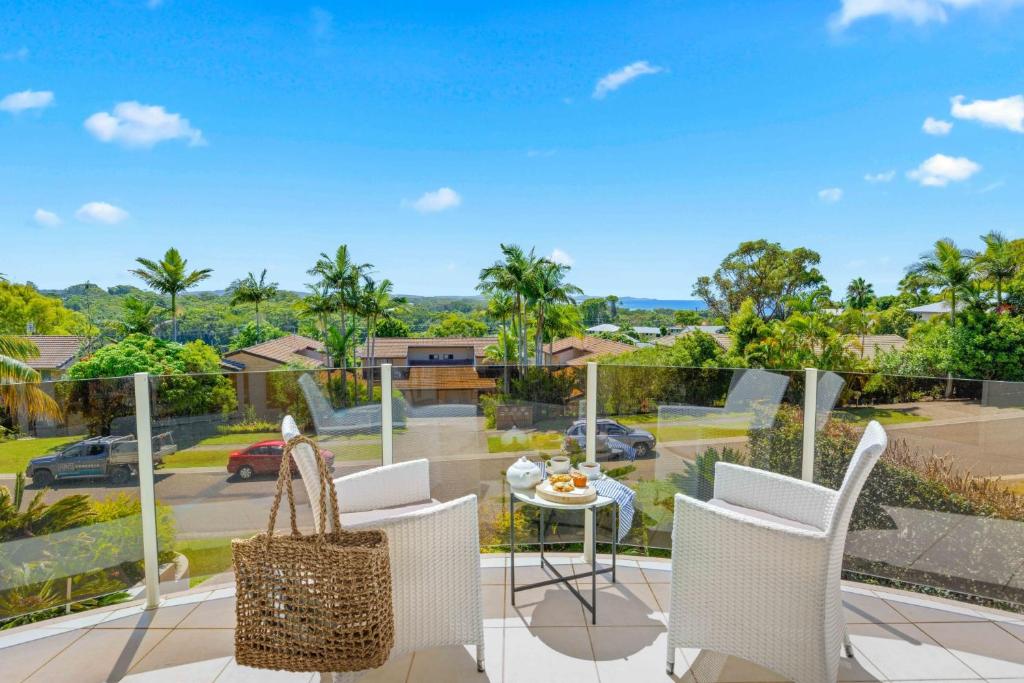 balcón con mesa y sillas y vistas a un aparcamiento en Paradise View @ Bonny Hills en Bonny Hills