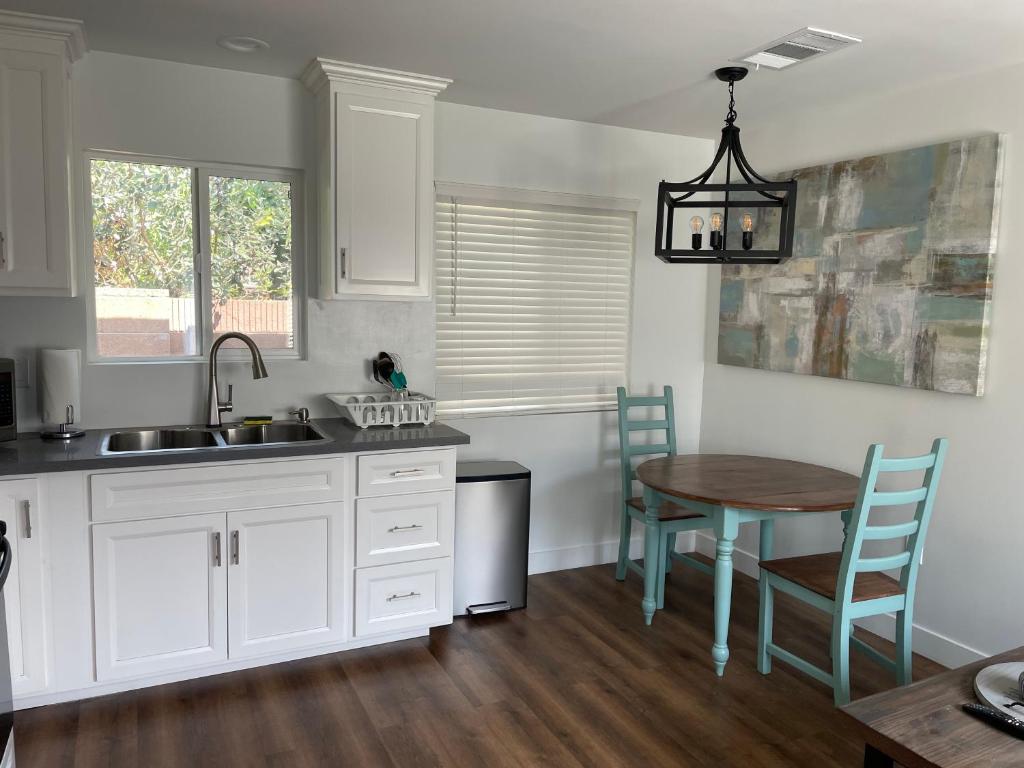 a kitchen with a sink and a table with chairs at Farmhouse Near Disneyland and Old Town Orange in Orange