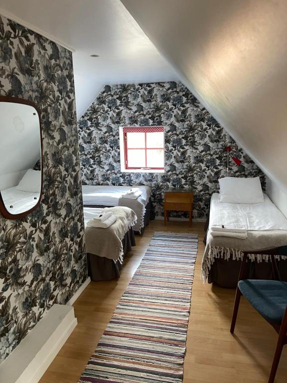 een kamer met een rij bedden en een spiegel bij Peppinge Bed & Breakfast in Löderup