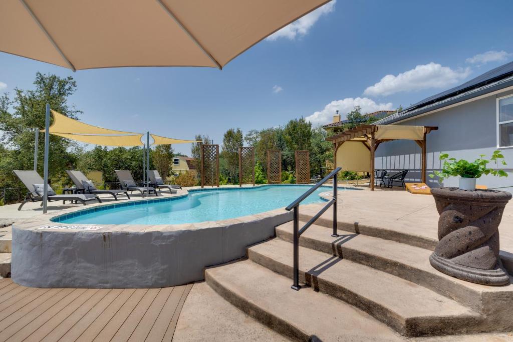 a swimming pool with stairs next to a house at 1-Story Hill Country Home Near Fiesta with Pool! in San Antonio