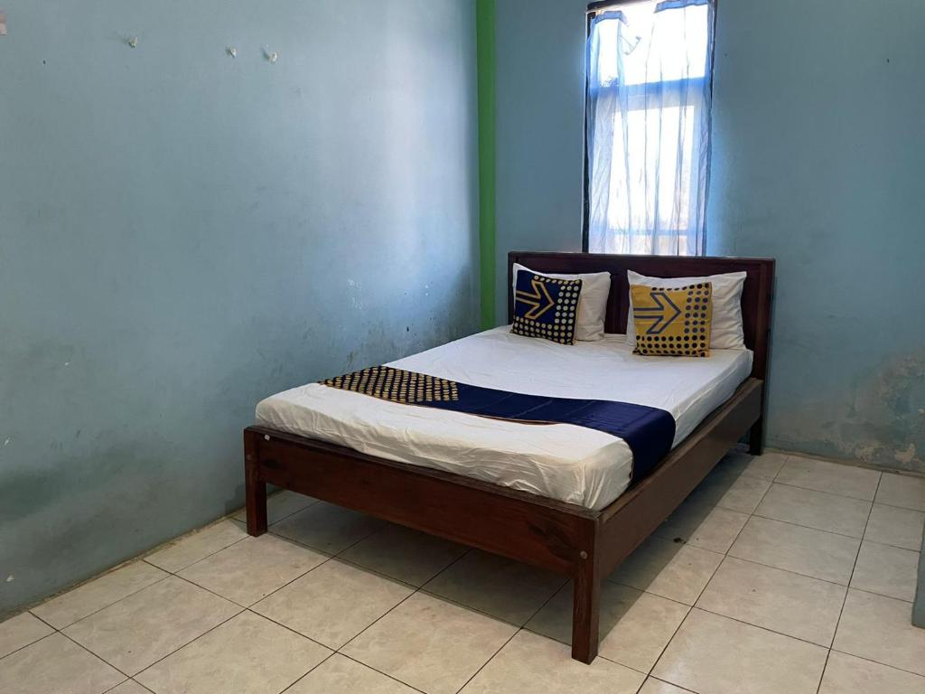 a small bed in a room with a window at SPOT ON 93037 Nova Jaya Homestay Syariah in Lamongan