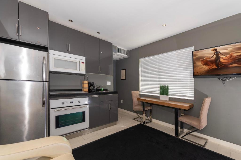 a kitchen with stainless steel appliances and a table at Sunny Days Apartments in Miami Beach